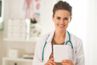 Young nurse standing smiling in clinic